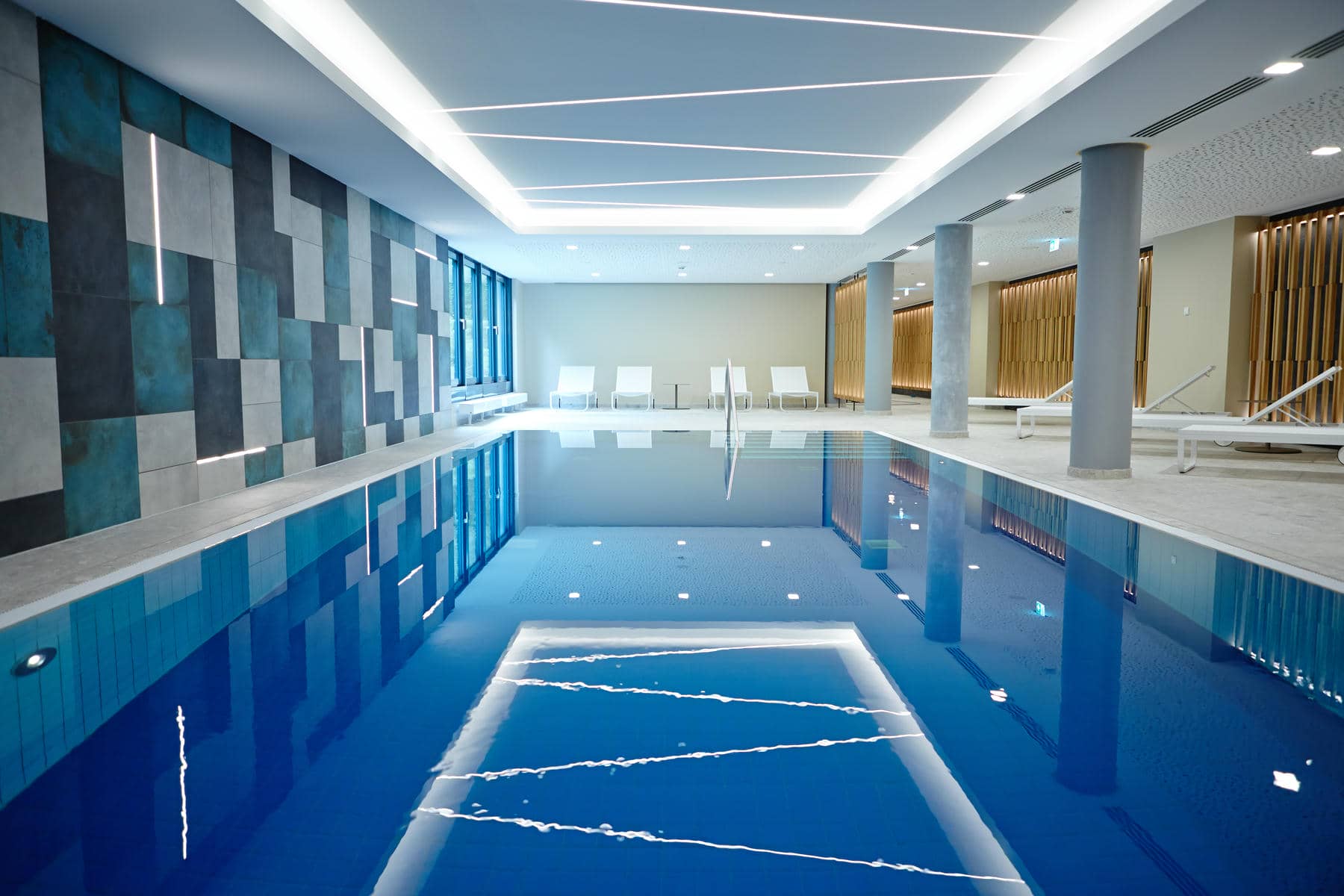 Indoor-Pool mit Tageslicht des Novotel München City mit Blick auf das Schwimmbecken und den Liegebereich