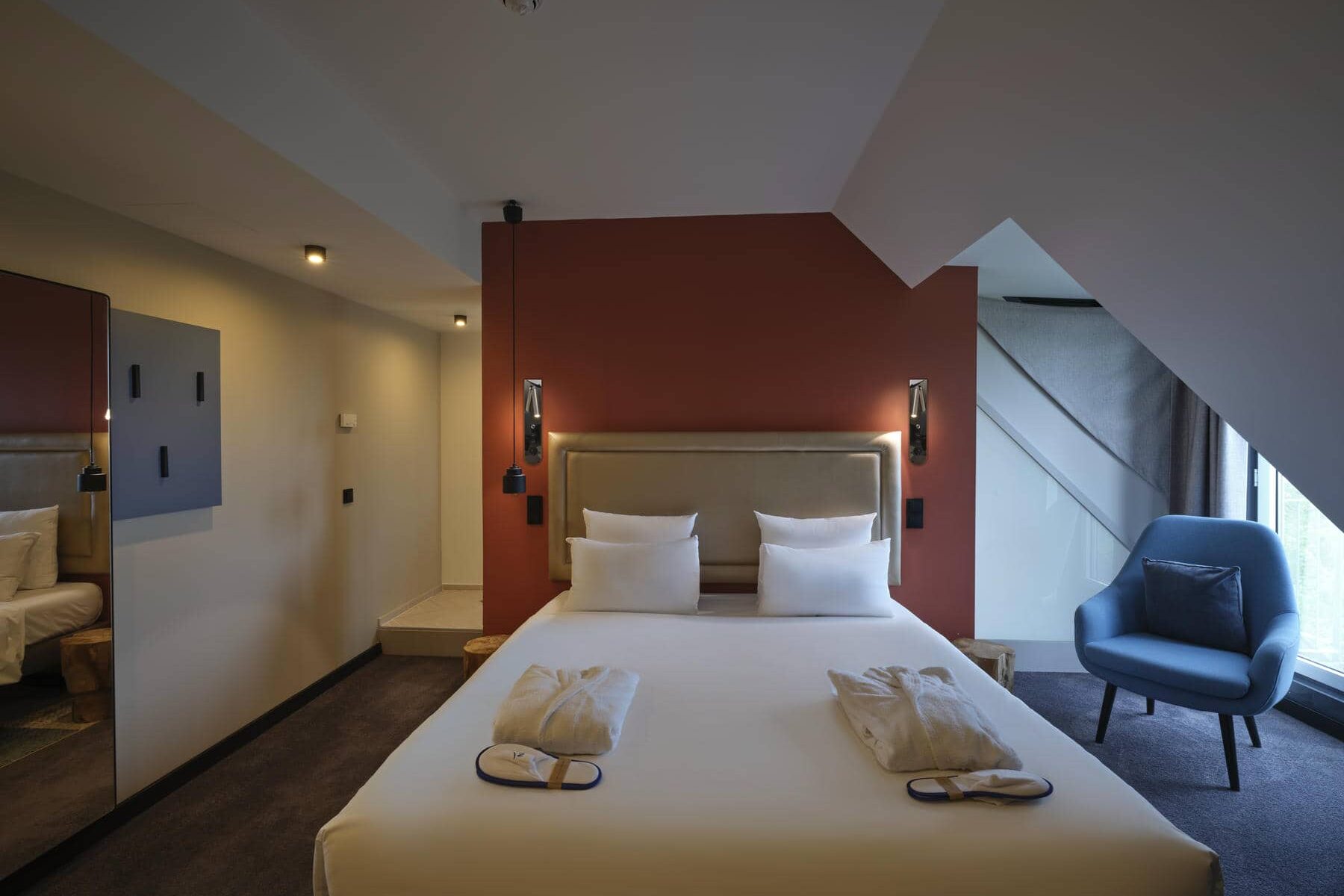 Schlafzimmer der Superior Suite mit großem Kingsize-Bett. gemütlichen Dachschrägen und großzügiger Raumaufteilung