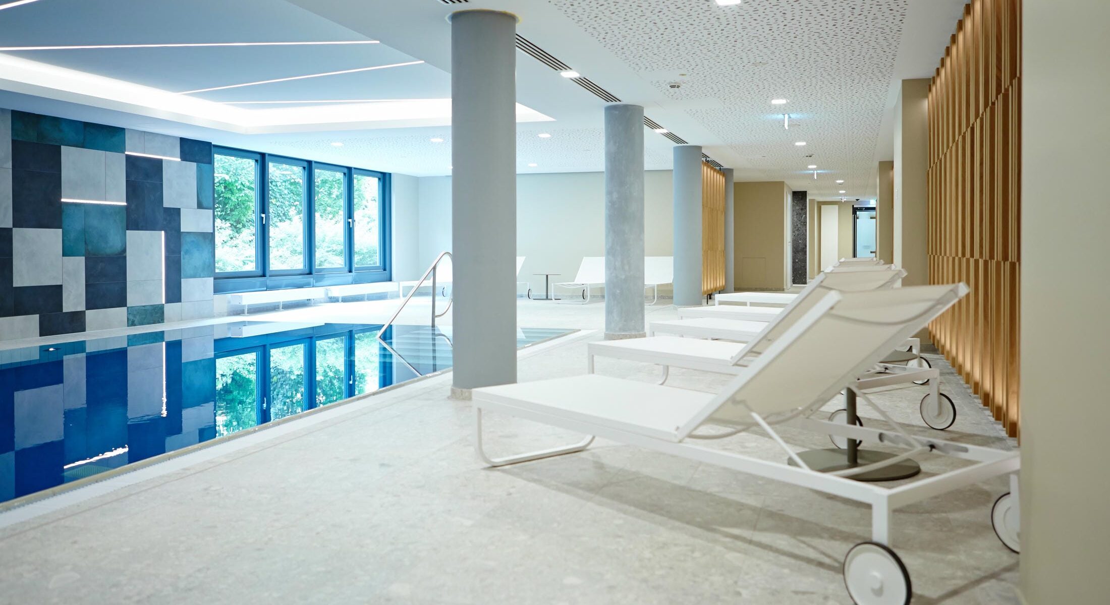 Indoor-Pool mit Tageslicht des Novotel München City mit Blick auf das Schwimmbecken und den Liegebereich