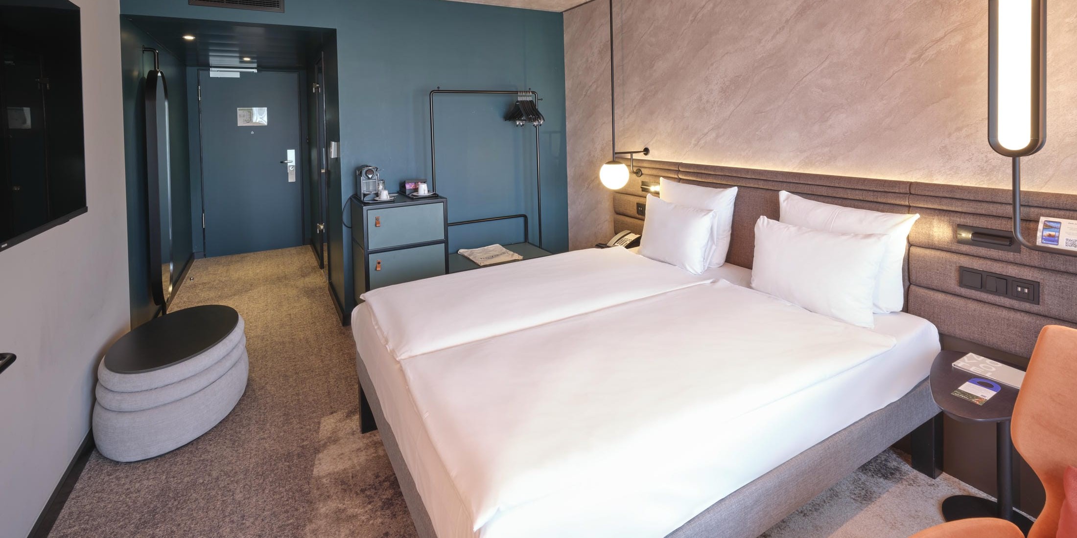 Blick vom Fenster in das Premium Doppelzimmer im Novotel München City mit Kingsize-Bett, Schreibtisch und modernem Dekor