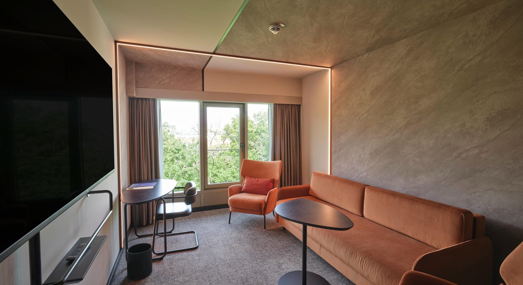 Premium Juniorsuite im Novotel München City mit separatem Wohnbereich., Kingsize-Bett, Schreibtisch, modernem Dekor und Blick auf die Stadt