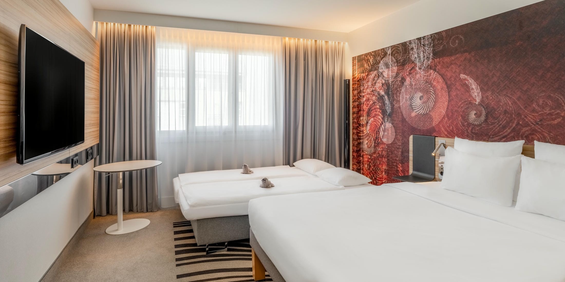 Standard Familienzimmer mit großem Doppelbett, Schlafsofa und Flachbild Fernseher im Novotel München City
