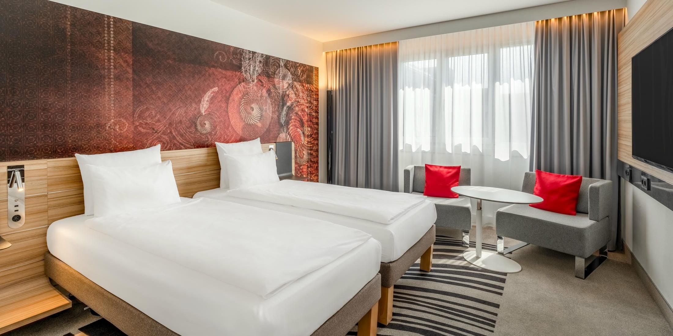 Standardzimmer mit zwei Einzelbetten, Sitzecke und Flachbildfernseher im Novotel München City
