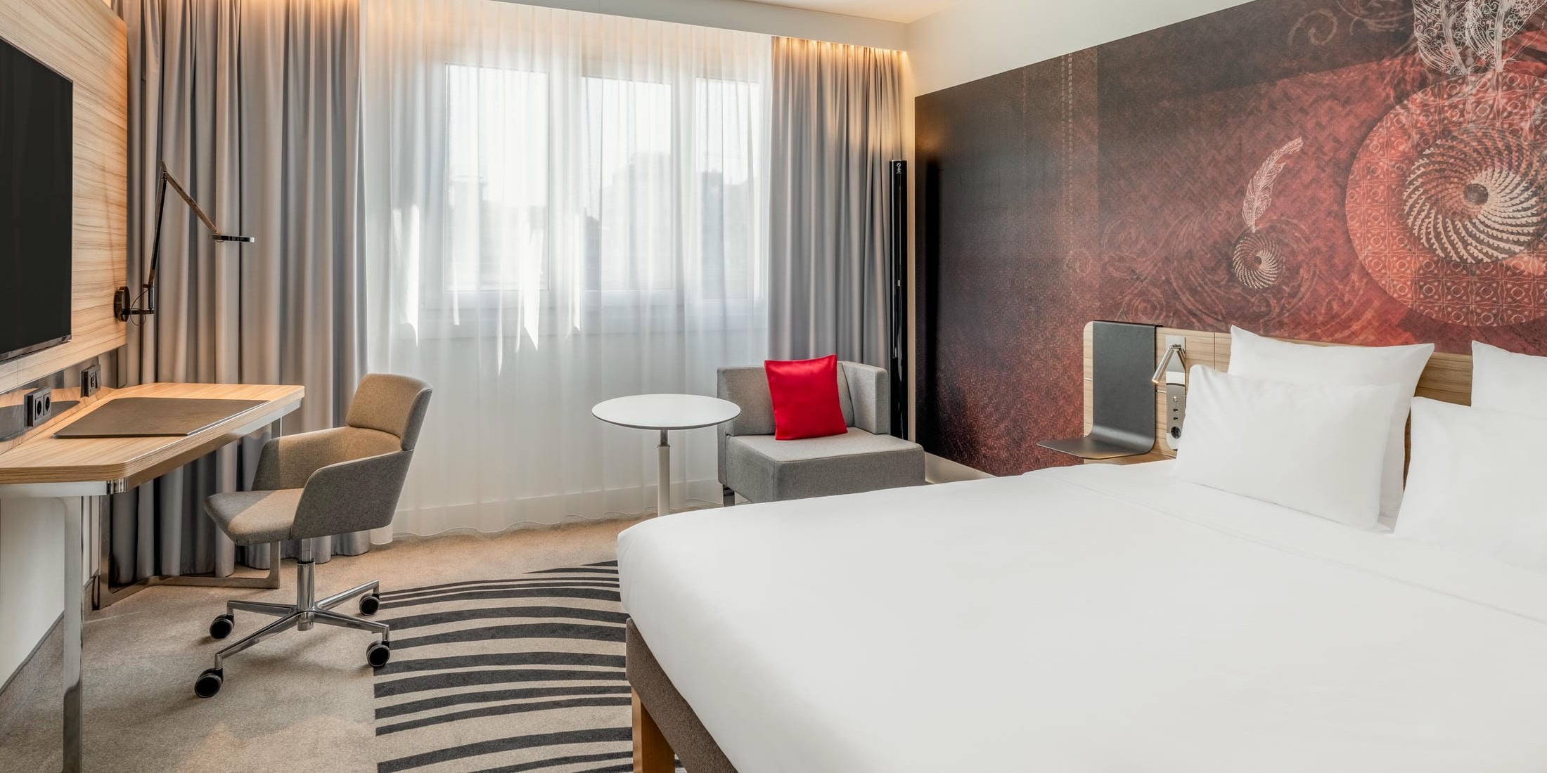 Superior Businesszimmer mit großem Doppelbett, Schreibtisch, Flachbild Fernseher und Sitzecke im Novotel München City